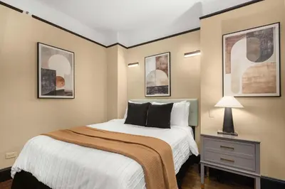 a bedroom with a bed and a table with a lamp at Stunning Apt in The Heart of New York City GYM in New York
