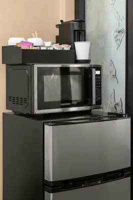 a microwave sitting on top of a refrigerator at Stunning Apt in The Heart of New York City GYM in New York