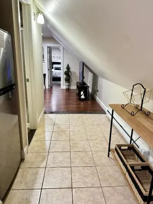 a living room with a staircase with a tiled floor at Private Cozy Apartment - Only 5 min Away from Newark Airport and 30 min to NYC in Elizabeth