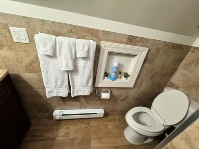 a bathroom with a toilet and towels on a wall at Private Cozy Apartment - Only 5 min Away from Newark Airport and 30 min to NYC in Elizabeth