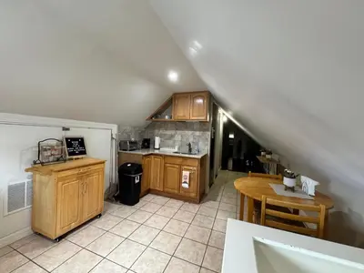 a kitchen with wooden cabinets and a table at Private Cozy Apartment - Only 5 min Away from Newark Airport and 30 min to NYC in Elizabeth