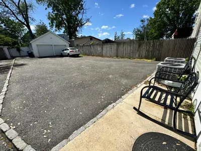 a parking lot with a bench in a driveway at Private Cozy Apartment - Only 5 min Away from Newark Airport and 30 min to NYC in Elizabeth