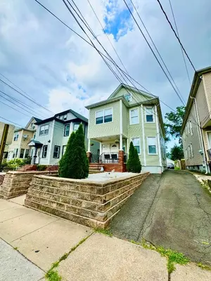 a house with a brick retaining wall in a street at Private Cozy Apartment - Only 5 min Away from Newark Airport and 30 min to NYC in Elizabeth