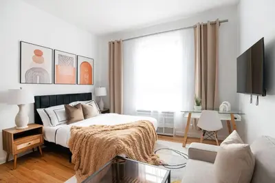 a white bedroom with a bed and a couch at 74-3C New Studio in Prime UWS - GYM In Building in New York