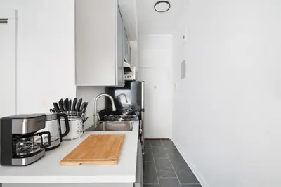a kitchen with white cabinets and a counter top at 74-3C New Studio in Prime UWS - GYM In Building in New York
