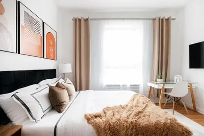 a bedroom with a bed with white sheets and a window at 74-3C New Studio in Prime UWS - GYM In Building in New York