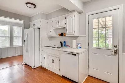 a kitchen with white cabinets and a white refrigerator at Madison Home Walk to Main Street! in Madison