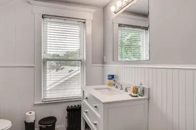 a white bathroom with a sink and a window at Madison Home Walk to Main Street! in Madison