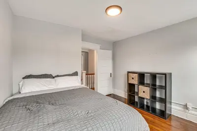 a bedroom with a bed and a white wall at Madison Home Walk to Main Street! in Madison