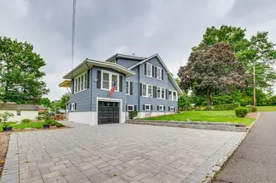 a large blue house with a driveway at Madison Home Walk to Main Street! in Madison