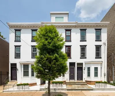 a white building with a tree in front of it at Live Loftily at University City in Philadelphia