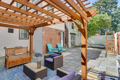 a wooden pergola on a patio with furniture at Live Loftily at University City in Philadelphia