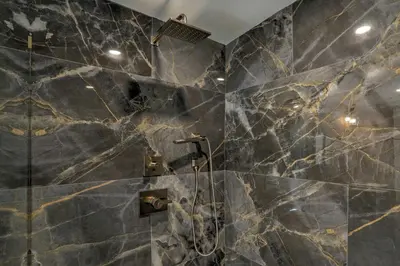 a bathroom with black marble walls and a shower at Live Loftily at University City in Philadelphia