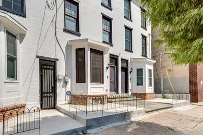 a white house with a fence in front of it at Live Loftily at University City in Philadelphia