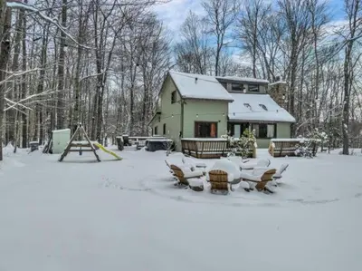 a house with a table and chairs in the snow at La Casita at Creekview in Gouldsboro