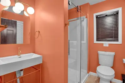 a bathroom with a toilet and a sink and a shower at La Casita at Creekview in Gouldsboro