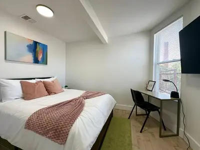 a bedroom with a bed and a desk and a window at Comfy NJ 2BR Close to Airport, Dream Mall & NYC in East Newark