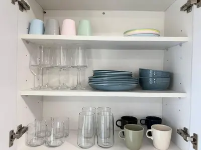 a shelf filled with glasses and plates and cups at Comfy NJ 2BR Close to Airport, Dream Mall & NYC in East Newark