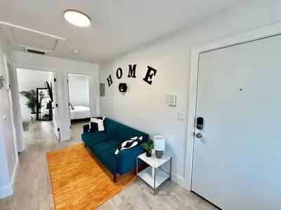 a living room with a blue couch and a table at Comfy NJ 2BR Close to Airport, Dream Mall & NYC in East Newark