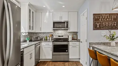 a kitchen with white cabinets and a stove top oven at Slopeside Escape by AvantStay Walk to Ski Lifts Arcade Games Shuffleboard in Tannersville
