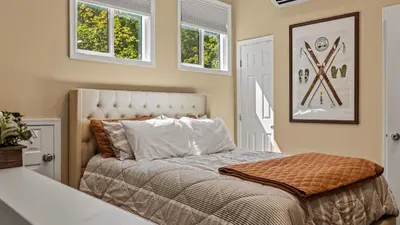 a bed in a room with windows and a bedvisor at Slopeside Escape by AvantStay Walk to Ski Lifts Arcade Games Shuffleboard in Tannersville