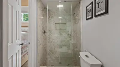 a white bathroom with a shower with a toilet at Slopeside Escape by AvantStay Walk to Ski Lifts Arcade Games Shuffleboard in Tannersville