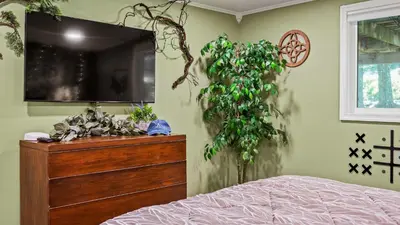 a bedroom with a dresser and a plant on the wall at Slopeside Escape by AvantStay Walk to Ski Lifts Arcade Games Shuffleboard in Tannersville