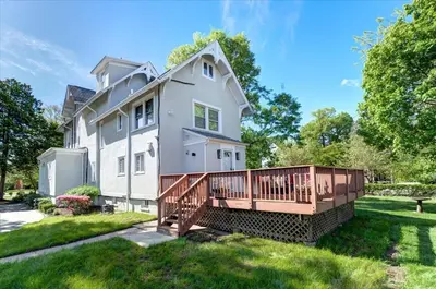 a large white house with a wooden deck at 7BR Spacious Property Perfect For up to 15! in Orange