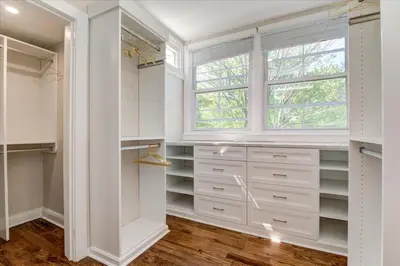 a walk in closet with white cabinets and a window at 7BR Spacious Property Perfect For up to 15! in Orange