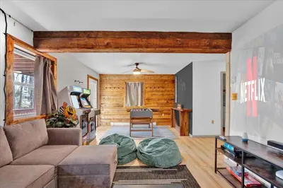 a living room with a couch and a table at Chalet Lake, Movie Theater, Hot Tub, Arcade in Gouldsboro