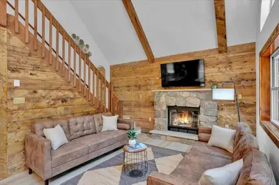 a living room with a couch and a fireplace at Chalet Lake, Movie Theater, Hot Tub, Arcade in Gouldsboro