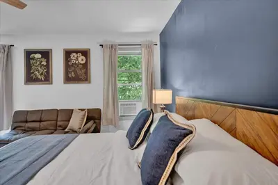 a bedroom with a bed and a blue wall at Chalet Lake, Movie Theater, Hot Tub, Arcade in Gouldsboro