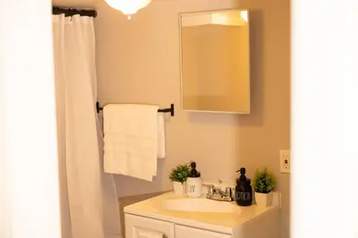 a bathroom with a sink and a mirror at Paloma - Lux Industrial Townhome in Newark