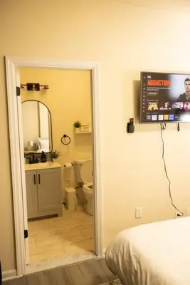a bathroom with a toilet and a tv on the wall at Paloma - Lux Industrial Townhome in Newark