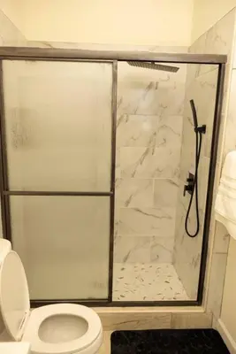 a bathroom with a shower with a toilet at Paloma - Lux Industrial Townhome in Newark