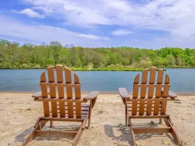 two chairs sitting on a beach near a body of water at Winter Hideaway - Sled Hill, Hot Tub, Fireplace, Game Room in Gouldsboro