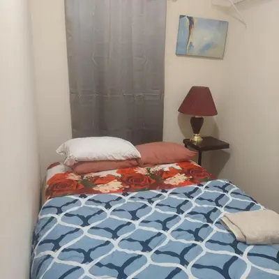 a bedroom with a bed with a blue and white comforter at Deluxe Room E in Jersey City