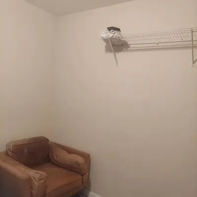 a living room with a couch and a shelf at Deluxe Room E in Jersey City