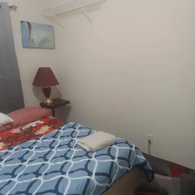 a bedroom with a bed with a blue and white comforter at Deluxe Room E in Jersey City