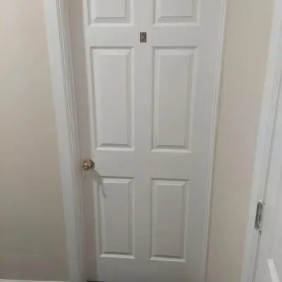 a white door with a brass door knob at Deluxe Room E in Jersey City