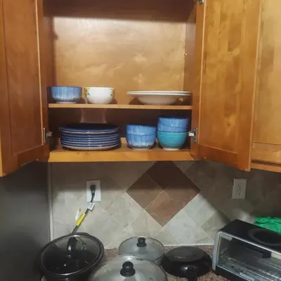 a kitchen with blue bowls and plates on a shelf at Deluxe Room E in Jersey City