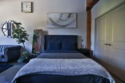 a bedroom with a bed with a blue bedspread at The Othello - Luxury Industrial Loft near NYC in Communipaw