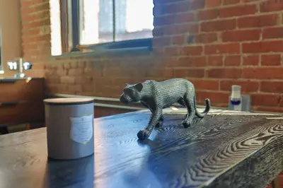 a figurine of a cat sitting on top of a table at The Othello - Luxury Industrial Loft near NYC in Communipaw