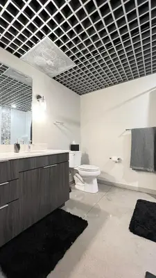 a bathroom with a toilet and a sink and a mirror at The Othello - Luxury Industrial Loft near NYC in Communipaw