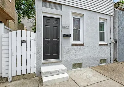 a house with a black door and a white fence at 2 Miles From Rocky Statue in Philadelphia
