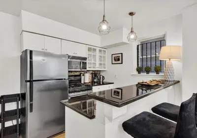 a kitchen with a stainless steel refrigerator and white cabinets at 2 Miles From Rocky Statue in Philadelphia