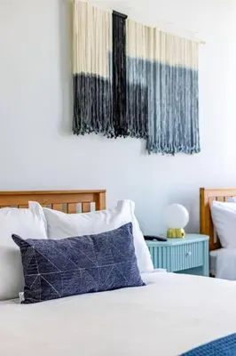 a bed with blue and white pillows on it at Modern Loft 15 Min from NYC with City View & Pool in Croxton