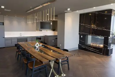 a kitchen with a wooden table and a fireplace at Modern Loft 15 Min from NYC with City View & Pool in Croxton