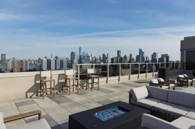 a rooftop patio with a view of a city at Modern Loft 15 Min from NYC with City View & Pool in Croxton