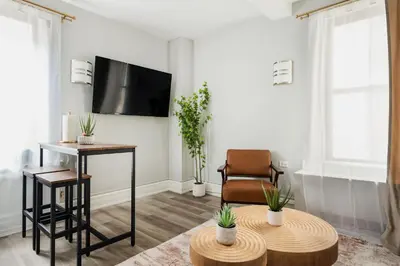 a living room with a tv and a chair and a table at 73-508 New 1BR 1Bth UWS Doorman Gym in New York